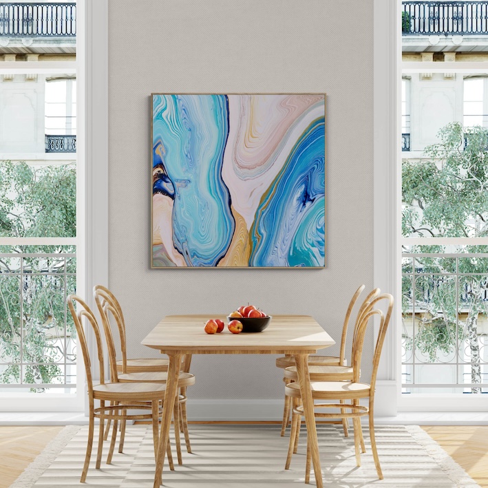 A dining area with a wooden table and chairs, a bowl of fruit on the table, and a large abstract painting titled "Emerald Dance" (101 x 101 cm) - Framed in Black on the wall. The room has floor-to-ceiling windows with views of greenery and balconies, perfectly framed in black for added elegance. Abstract Art by Thanh Lyons